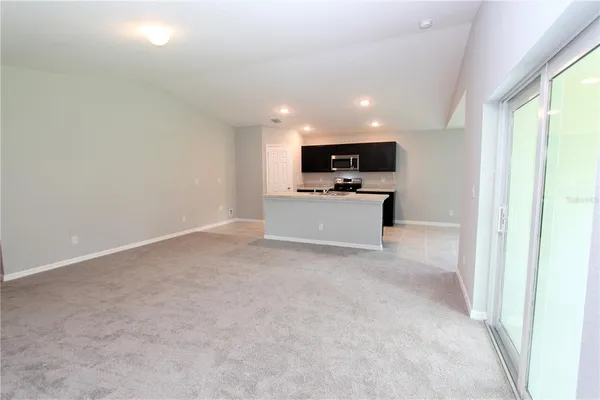 a view of kitchen with microwave oven stove and cabinets
