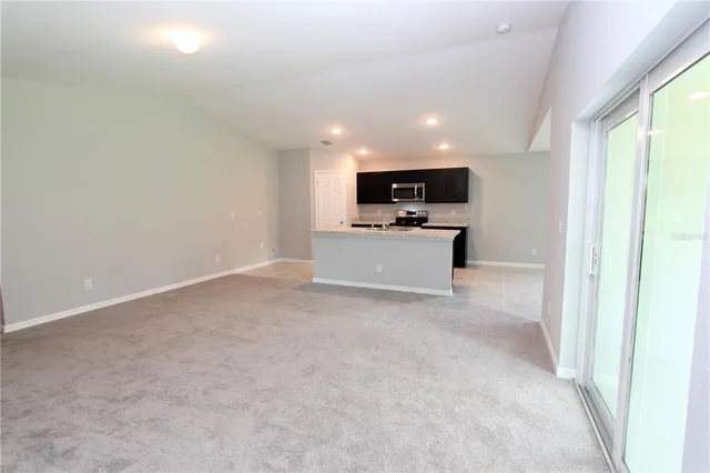 a view of kitchen with microwave oven stove and cabinets