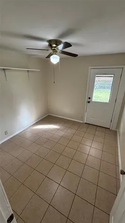 an empty room with windows and ceiling fan