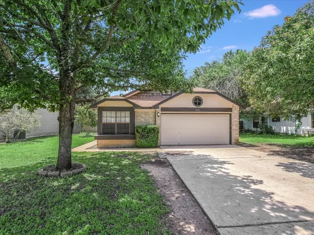 a front view of a house with a yard and trees