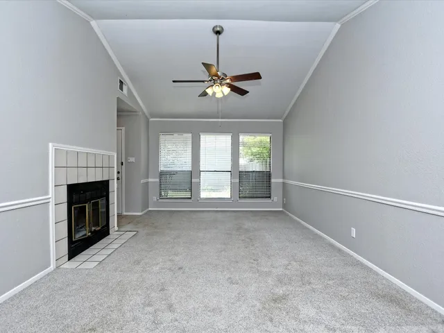 a view of empty room with fireplace and windows