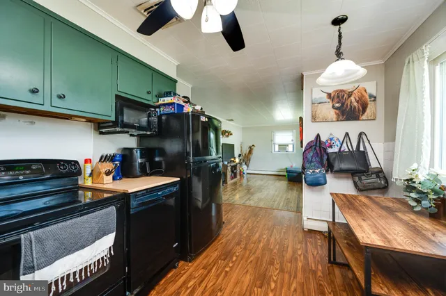 a kitchen view of a kitchen island a stove and a wooden floors
