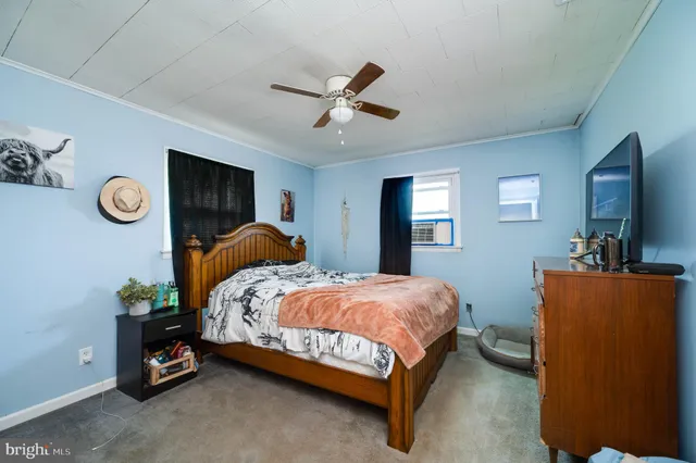 a bedroom with a bed and a flat tv screen on dresser