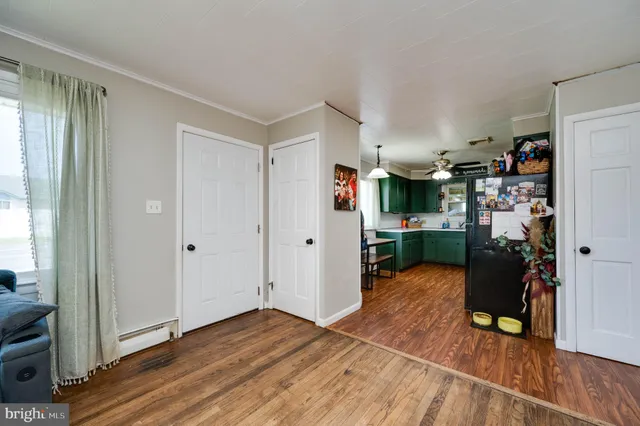 a view of a livingroom with wooden floor and a ceiling fan