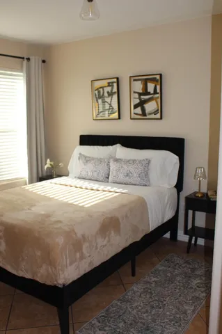 a bedroom with a bed and painting on the wall