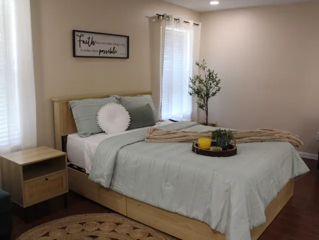 a bedroom with a bed and potted plant