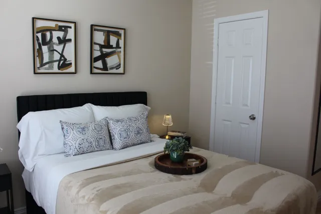 a bedroom with a bed and painting on the wall