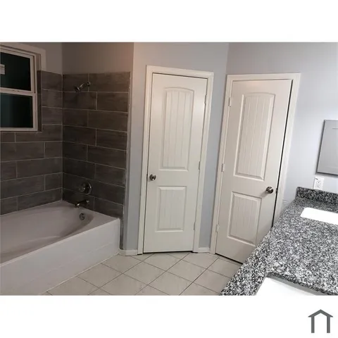 a bathroom with a tub shower and sink