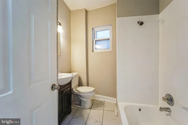 a bathroom with a toilet a sink a mirror and vanity