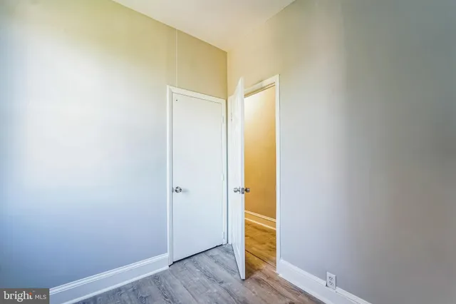 an empty room with wooden floor and a window