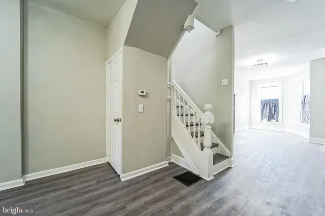 an entryway with wooden floor and staircase