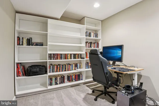 a view of a workspace with furniture and a book shelf