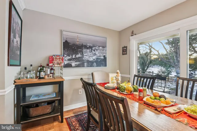 a view of a dining room with furniture a rug and wooden floor