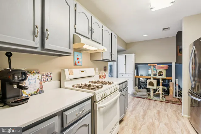 a kitchen with stainless steel appliances a stove a sink and a refrigerator