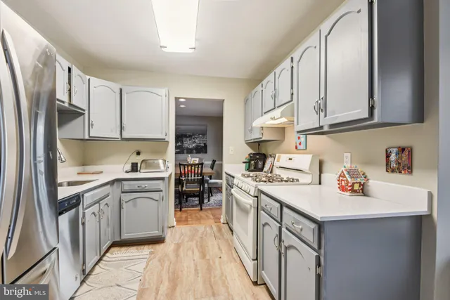a kitchen with stainless steel appliances granite countertop a sink stove refrigerator and cabinets