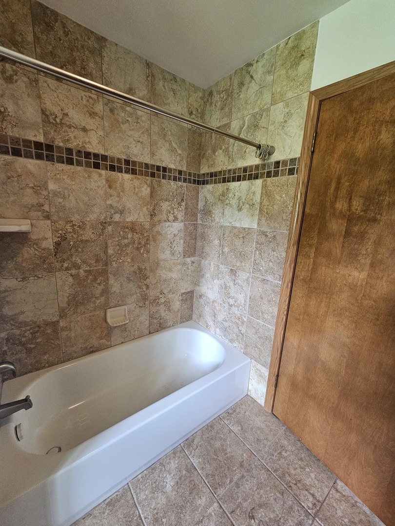 23025 Hazel Road Sterling, IL 61081 - Photo 8 of 29 a bathroom with a bathtub and a shower