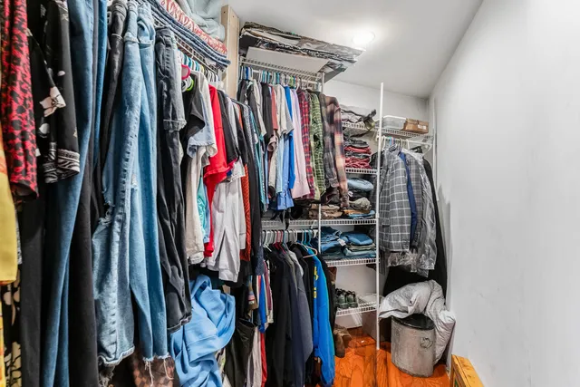 a view of walk in closet with clothes