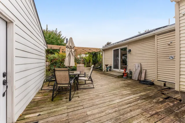 a view of a patio with table and chairs with wooden floor and fence
