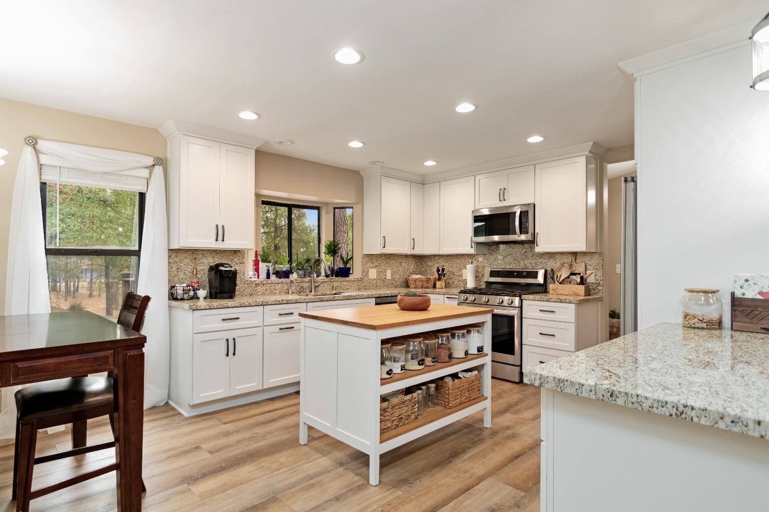 a kitchen with white cabinets and appliances