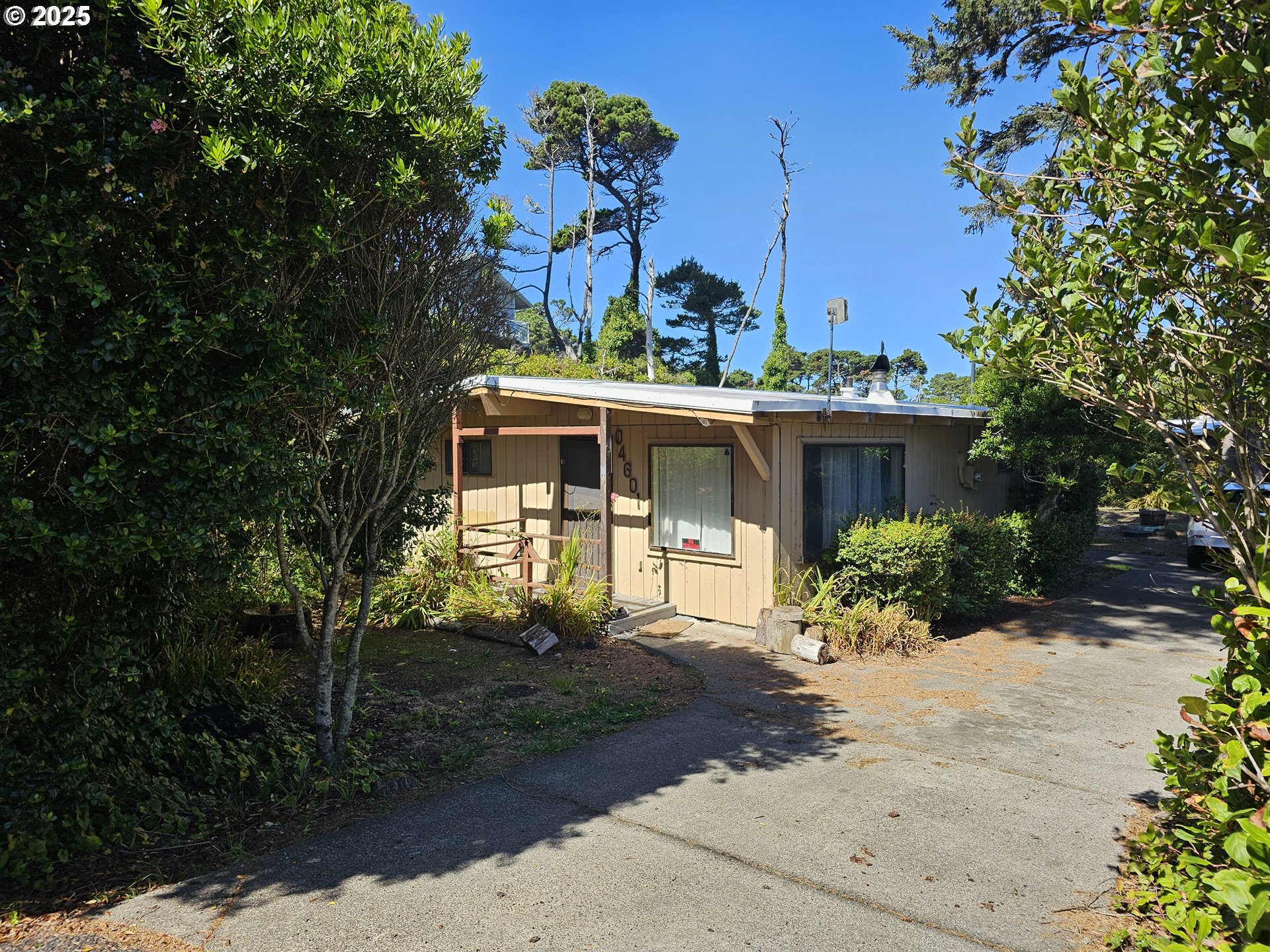 a front view of a house with a garden and trees