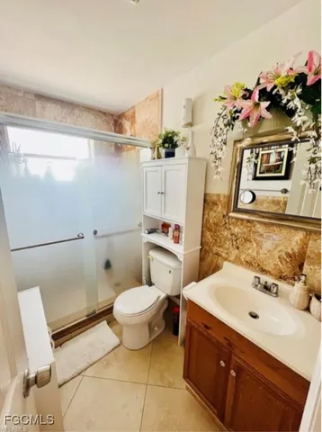 a bathroom with a sink mirror toilet and shower