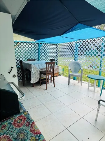 a view of a chairs and table in back yard of a house