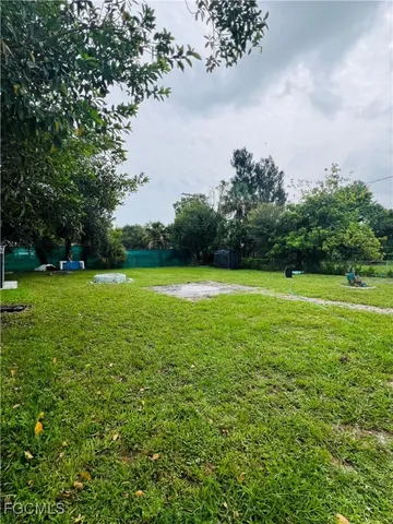 a view of a green field with wooden fence