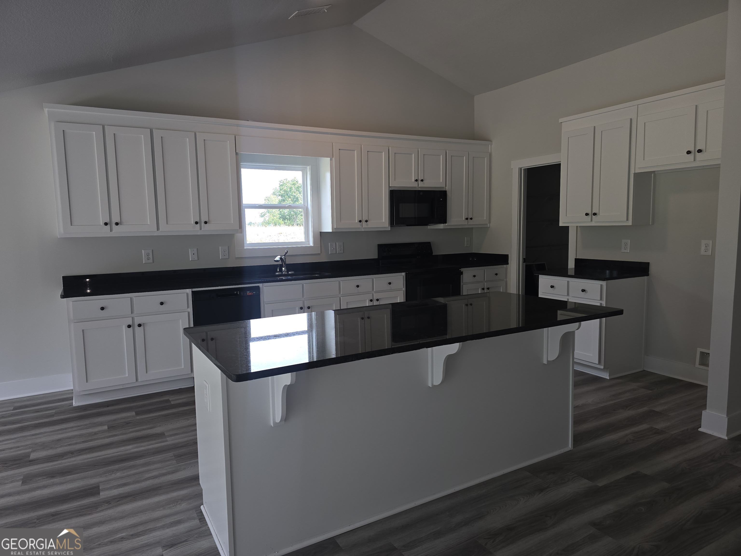 51 Champions Lane, Unit 2 Winder, GA 30680 - Photo 2 of 16 a kitchen with stainless steel appliances kitchen island granite countertop a stove a sink and a refrigerator