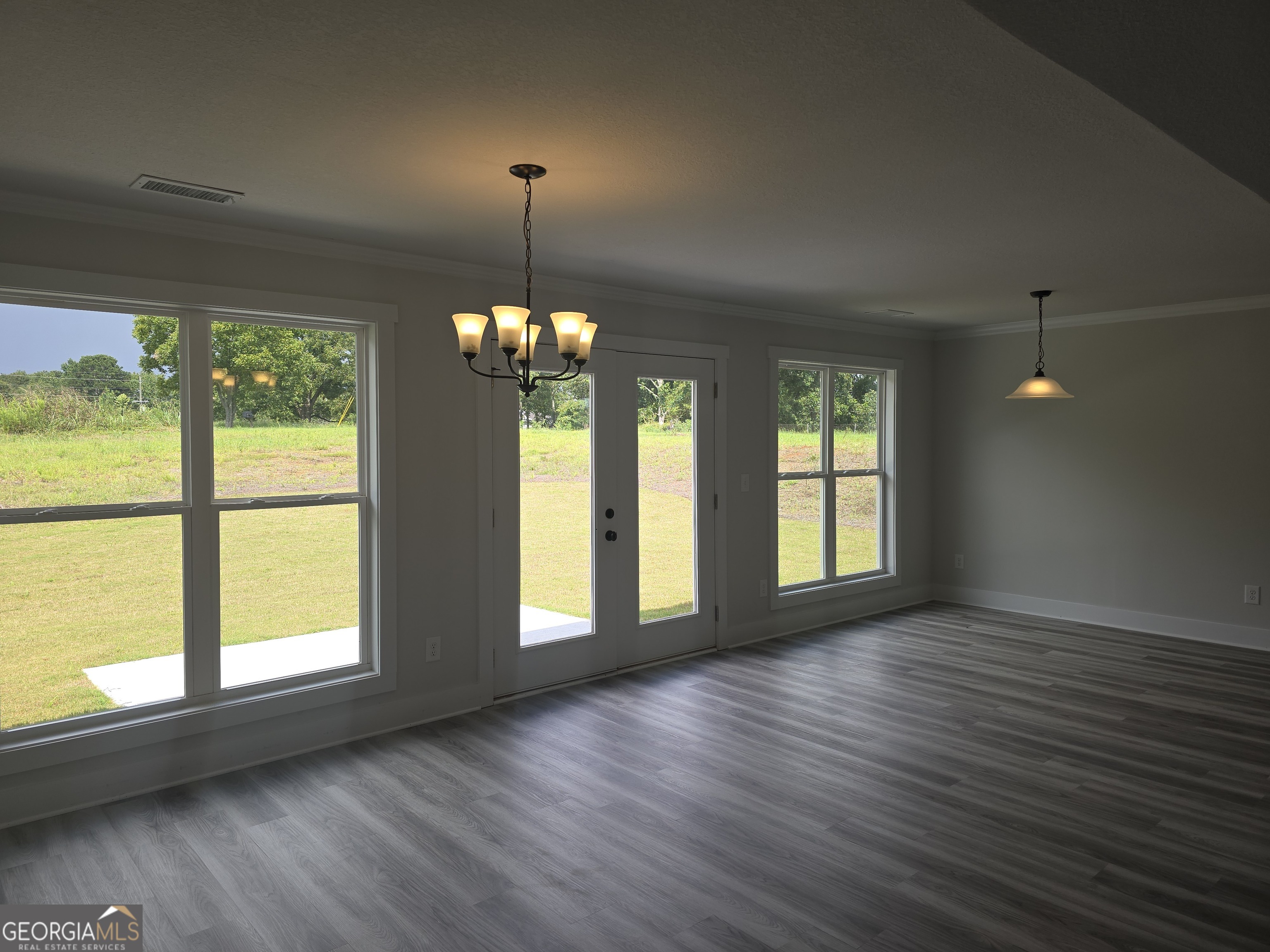 51 Champions Lane, Unit 2 Winder, GA 30680 - Photo 3 of 16 an empty room with wooden floor and windows