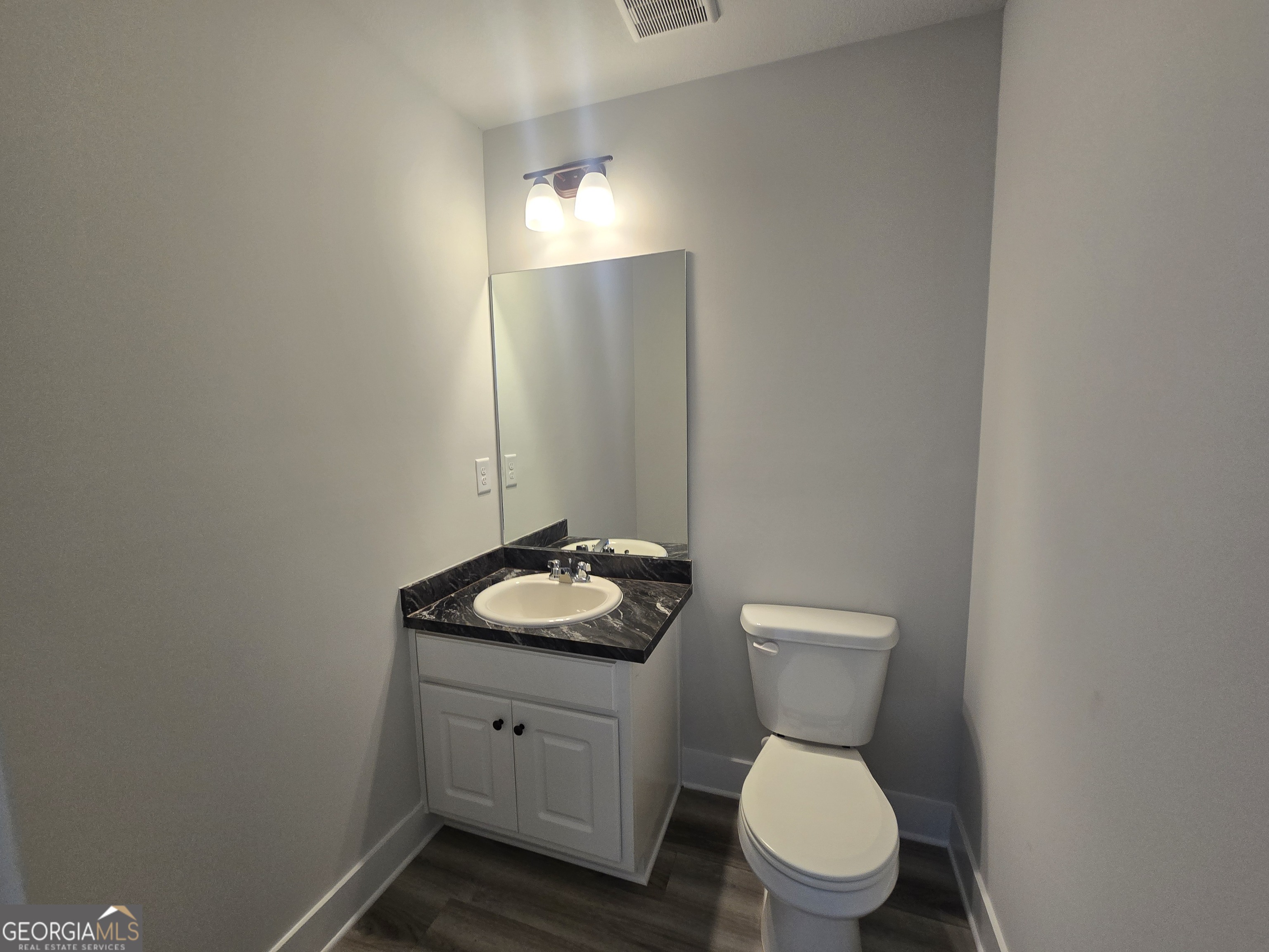 51 Champions Lane, Unit 2 Winder, GA 30680 - Photo 6 of 16 a bathroom with a toilet sink vanity and mirror