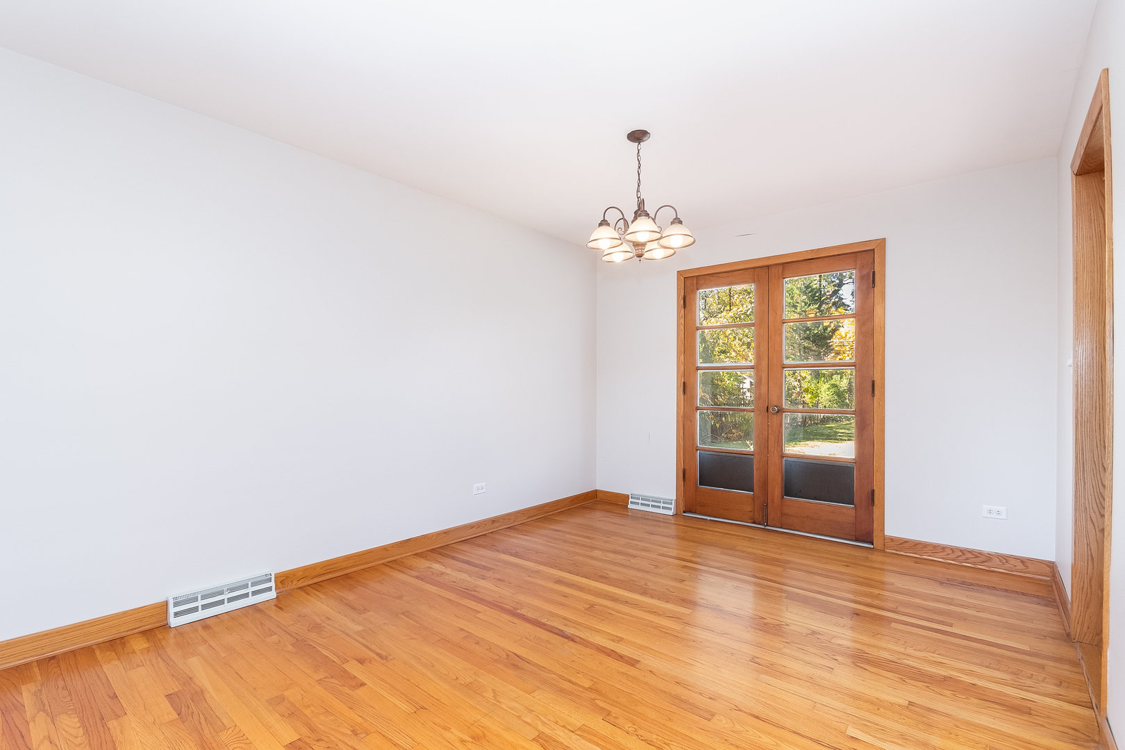 8 South Mt Prospect Road Mount Prospect, IL 60056 - Photo 5 of 25 a view of an empty room with wooden floor and a window