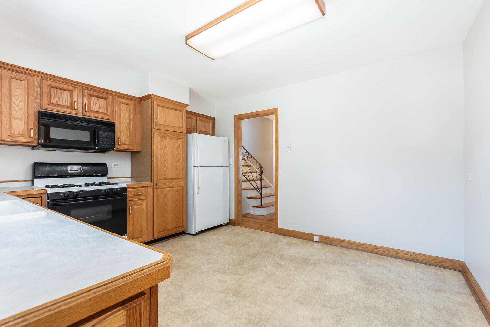 8 South Mt Prospect Road Mount Prospect, IL 60056 - Photo 8 of 25 a view of a kitchen with refrigerator stove wooden floor and windows