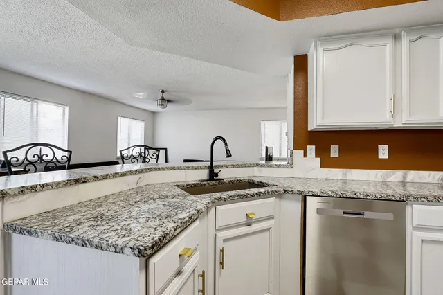 a kitchen with granite countertop a sink and cabinets