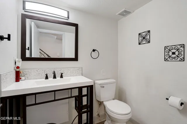 a bathroom with a toilet a sink and mirror