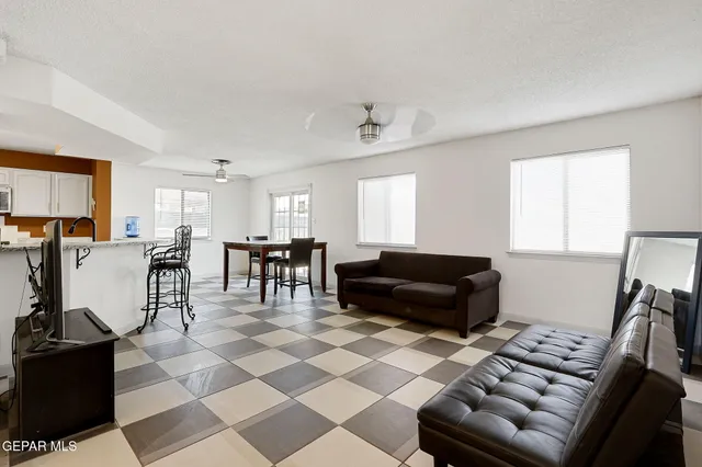 a living room with furniture and a dining table with kitchen view