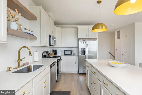 a kitchen with a sink a stove cabinets and counter space