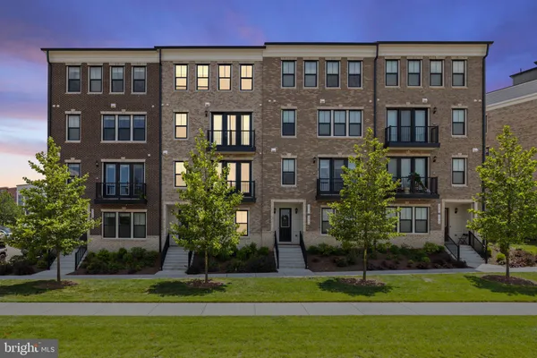 a front view of a residential apartment building with a yard
