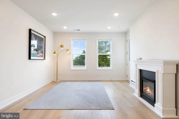 an entryway and livingroom with fireplace wooden floor and window