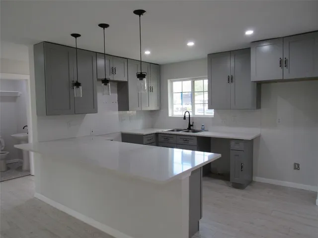 a large kitchen with stainless steel appliances kitchen island granite countertop a sink a stove and a refrigerator