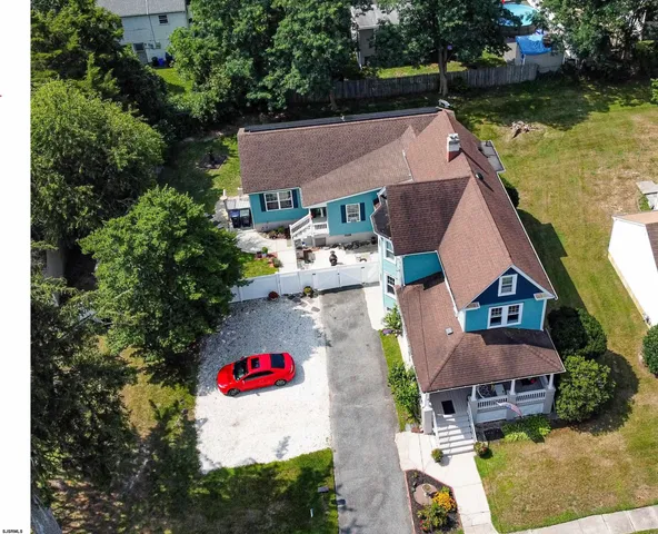an aerial view of residential house with outdoor space and trees all around