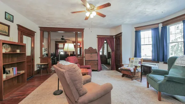 a living room with furniture a bookshelf and a window