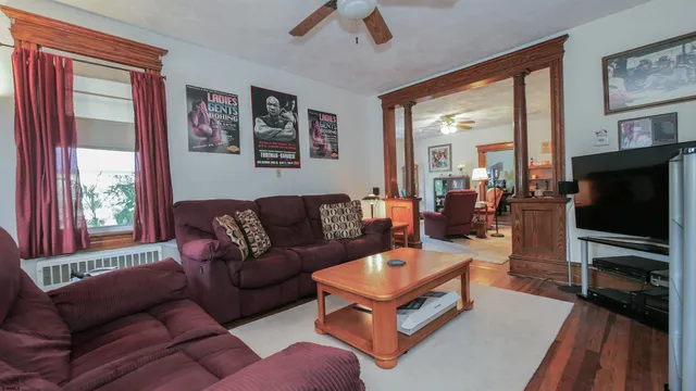 a living room with furniture a flat screen tv and a large window