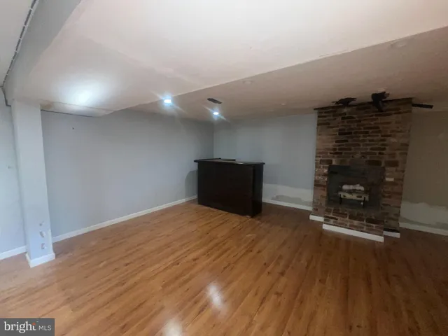 a view of empty room with wooden floor and fireplace