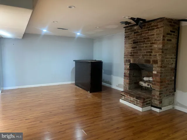 a room with a fireplace and a wooden floor