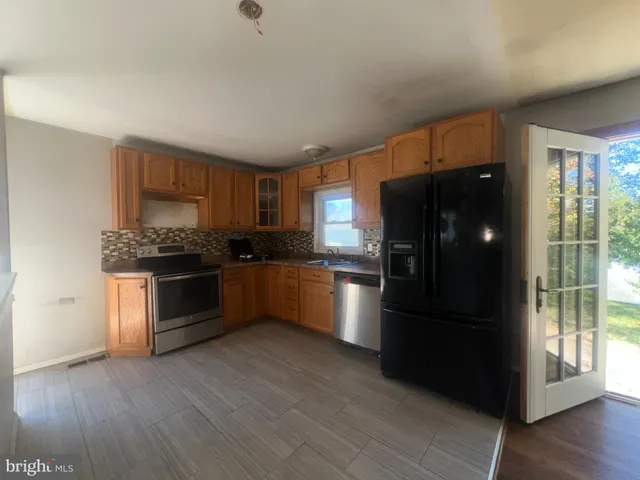 a kitchen with a refrigerator and a stove top oven