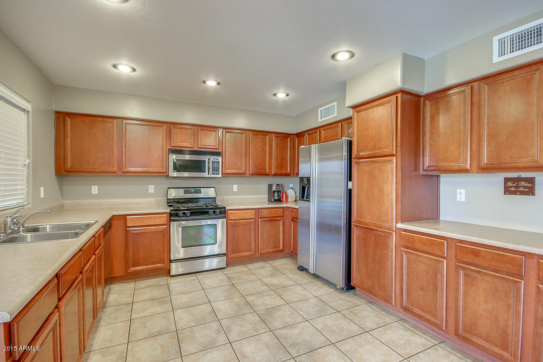 5362 West Pecan Road Laveen, AZ 85339 - Photo 8 of 28 a kitchen with stainless steel appliances granite countertop a refrigerator sink and cabinets