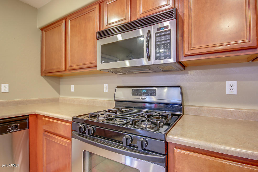 5362 West Pecan Road Laveen, AZ 85339 - Photo 9 of 28 a kitchen with stainless steel appliances granite countertop a stove and a microwave