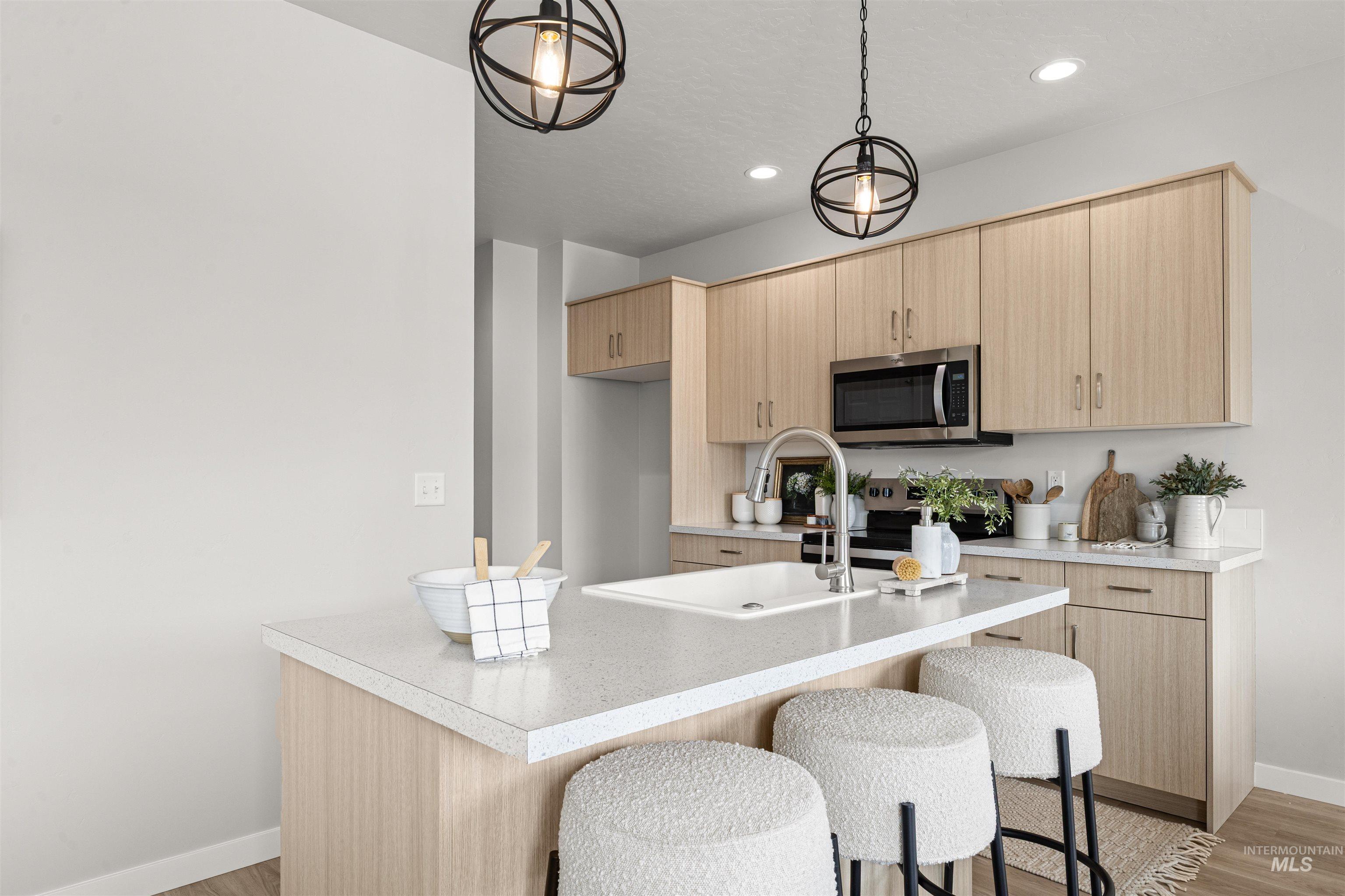 2526 West Fallon Loop Nampa, ID 83651 - Photo 10 of 32 Kitchen with light wood finish cabinets, a kitchen breakfast bar, and light countertops