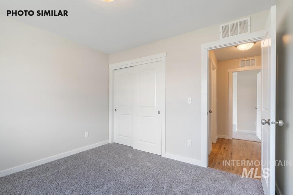 1708 Rapid Road Emmett, ID 83617 - Photo 18 of 33 Carpeted interior room featuring a bi-fold closet with white paneled doors, light grey wall paint, and white trim