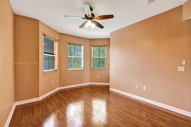 an empty room that has a window and wooden floor